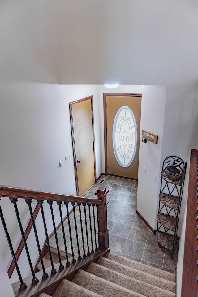 entrance foyer featuring stairway and baseboards