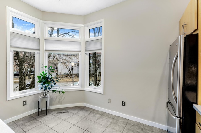 unfurnished dining area with light tile patterned floors, visible vents, and baseboards