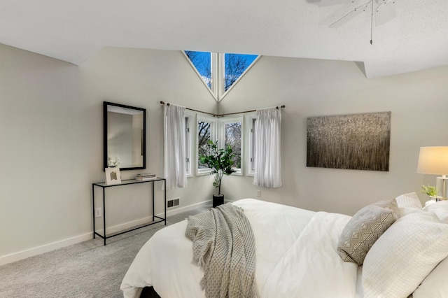 carpeted bedroom with lofted ceiling with skylight, baseboards, visible vents, and ceiling fan