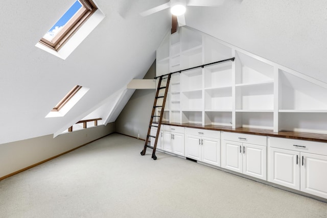 bonus room with lofted ceiling with skylight and light colored carpet