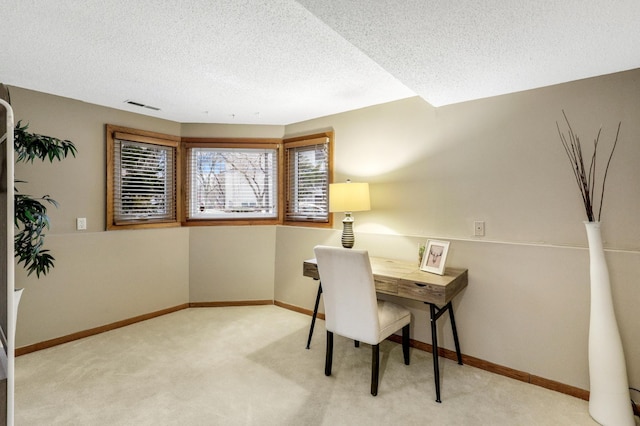 office area featuring light carpet, baseboards, visible vents, and a textured ceiling