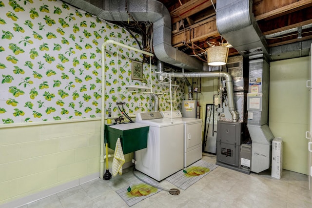 washroom with washing machine and dryer, laundry area, a sink, water heater, and heating unit