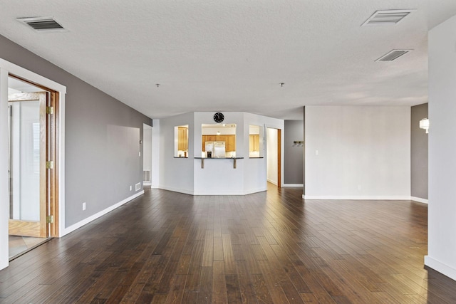 unfurnished living room featuring baseboards, visible vents, and dark wood-style flooring