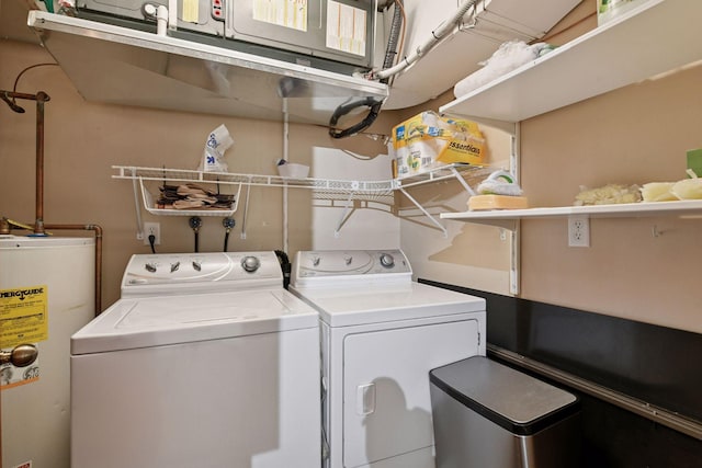 clothes washing area with laundry area, separate washer and dryer, and electric water heater