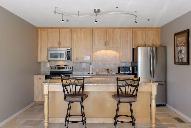 kitchen with tasteful backsplash, light brown cabinets, and appliances with stainless steel finishes