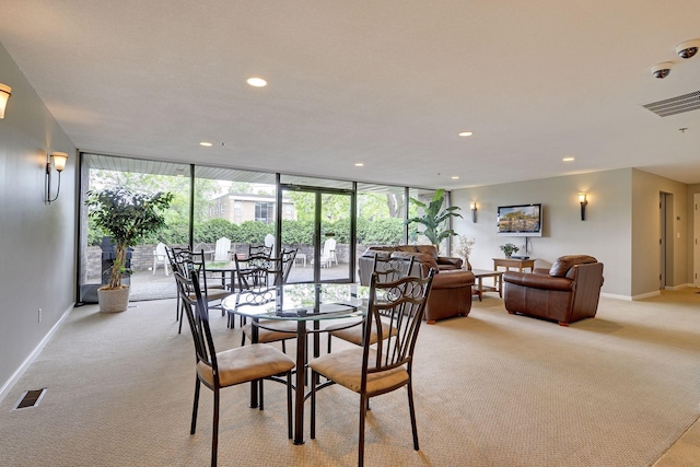 dining space featuring baseboards, floor to ceiling windows, visible vents, and light colored carpet