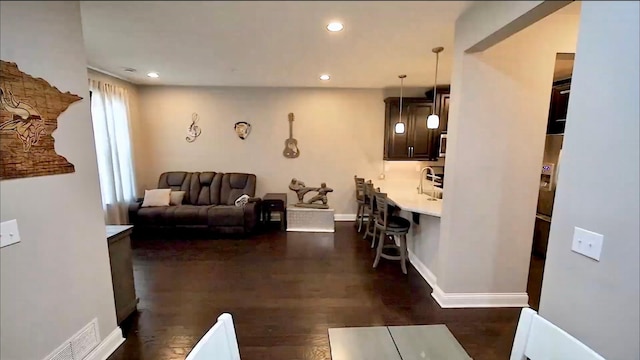 living room featuring dark wood-type flooring, recessed lighting, visible vents, and baseboards