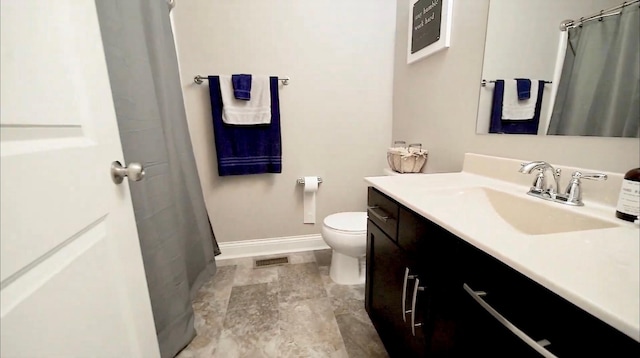 full bath featuring curtained shower, visible vents, toilet, vanity, and baseboards