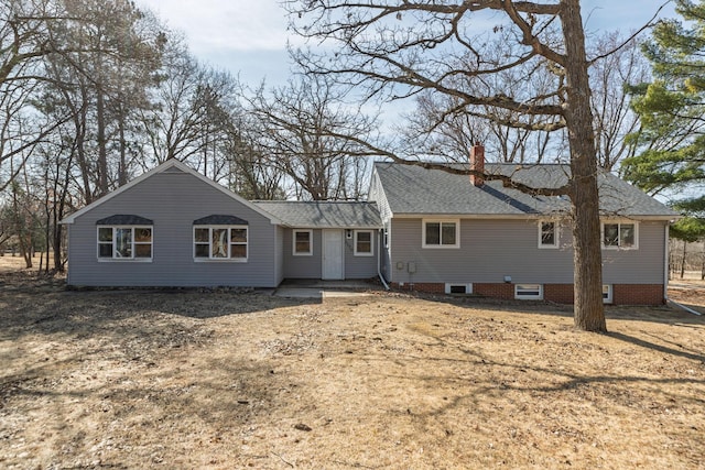 back of property featuring roof with shingles and a chimney