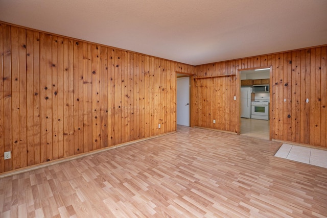 spare room with baseboards and wood finished floors