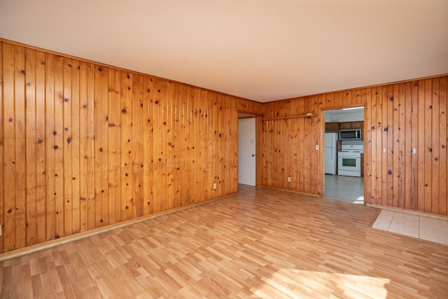 unfurnished room featuring baseboards and light wood finished floors