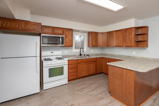 kitchen with a sink, open shelves, white appliances, a peninsula, and brown cabinetry