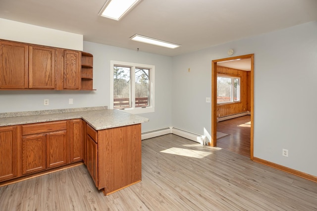 kitchen with baseboard heating, a healthy amount of sunlight, a peninsula, and open shelves