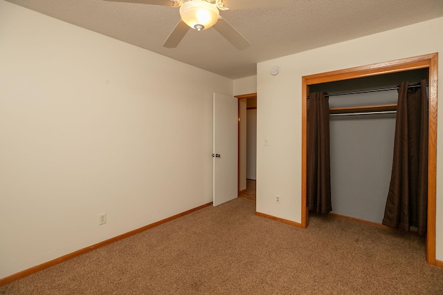 unfurnished bedroom with baseboards, ceiling fan, a closet, a textured ceiling, and carpet flooring