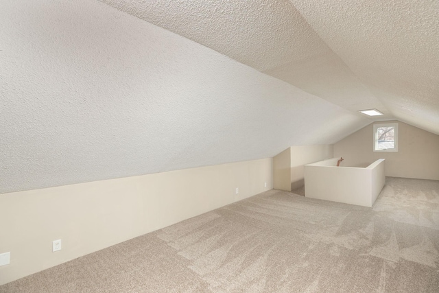 bonus room featuring a textured ceiling, carpet, and vaulted ceiling