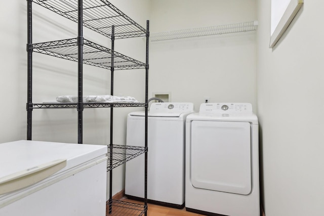 laundry area with light wood-type flooring, laundry area, and washing machine and clothes dryer