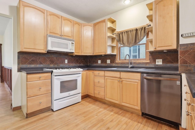 kitchen with light brown cabinetry, white appliances, a sink, and open shelves