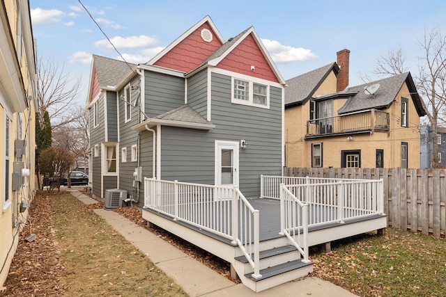 rear view of property featuring central AC, fence, a deck, and roof with shingles