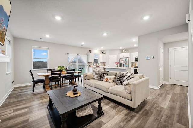 living area with recessed lighting, baseboards, and light wood-style floors