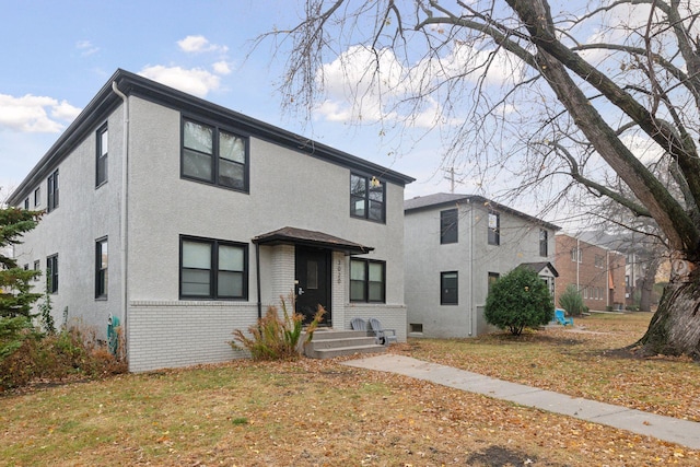 view of front of home with stucco siding and brick siding