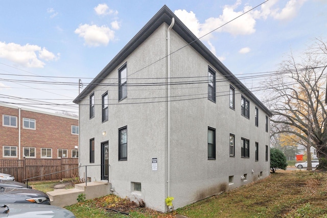 view of property exterior featuring fence and stucco siding