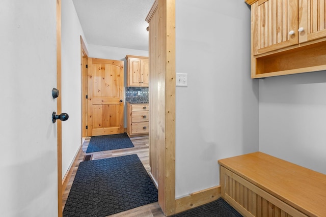 mudroom with light wood finished floors and baseboards