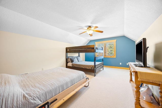 bedroom featuring lofted ceiling, a textured ceiling, carpet floors, a ceiling fan, and baseboards