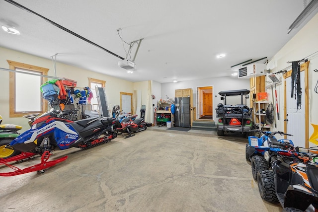 garage with stainless steel fridge and a garage door opener