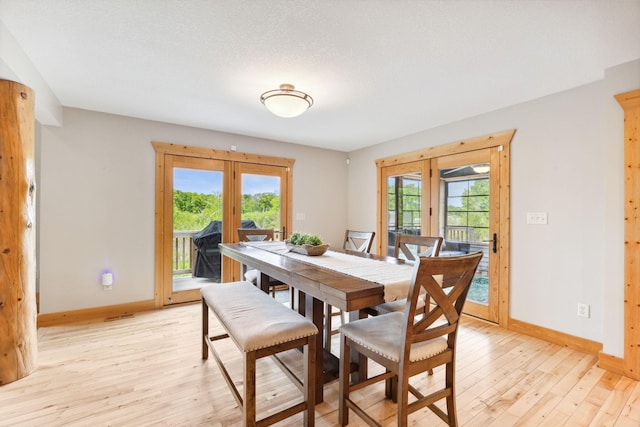 29235 Piney Way, Breezy Point, MN 56472 - dining area featuring french doors, baseboards, light wood finished floors, and plenty of natural light