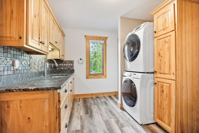 29235 Piney Way, Breezy Point, MN 56472 - laundry room featuring stacked washer / dryer, cabinet space, light wood finished floors, baseboards, and a textured ceiling