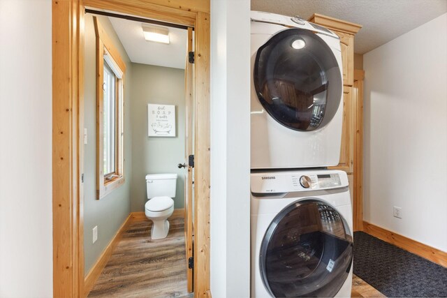 29235 Piney Way, Breezy Point, MN 56472 - laundry room with stacked washer / dryer, wood finished floors, and baseboards