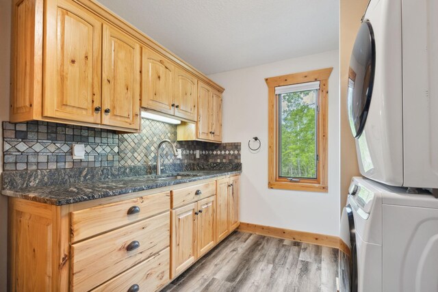 29235 Piney Way, Breezy Point, MN 56472 - washroom featuring estacked washer and dryer, light wood-type flooring, baseboards, and cabinet space