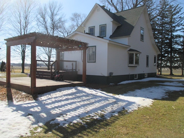 view of home's exterior featuring a shingled roof, a deck, and a pergola