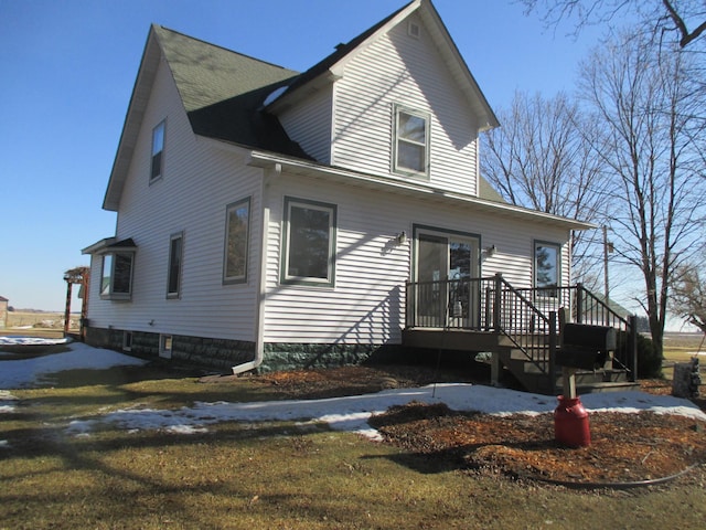 view of front of property featuring roof with shingles and a wooden deck