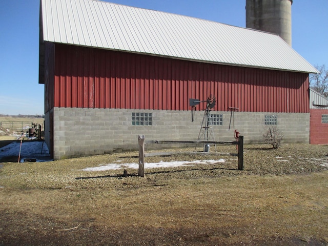 view of home's exterior featuring a pole building, an outdoor structure, a chimney, and metal roof