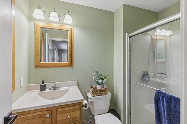 bathroom with a shower stall, toilet, and vanity