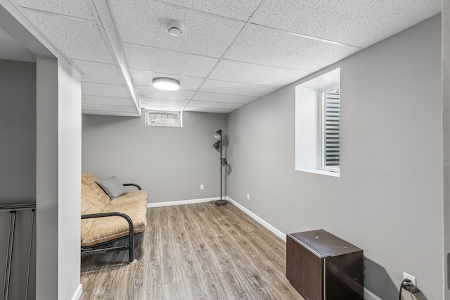 sitting room with a paneled ceiling, baseboards, and wood finished floors