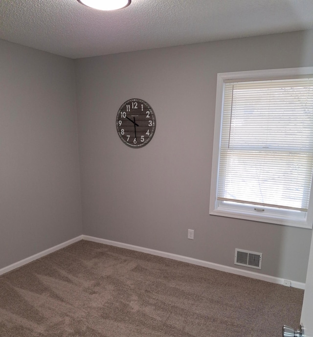 unfurnished room featuring visible vents, a textured ceiling, baseboards, and carpet floors