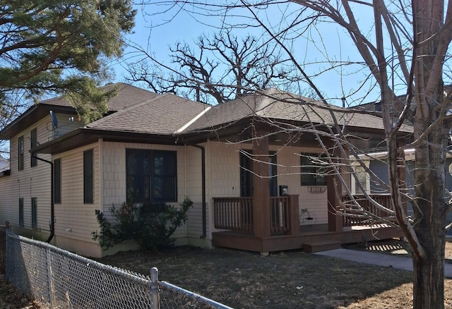 view of front of property with fence private yard and a shingled roof