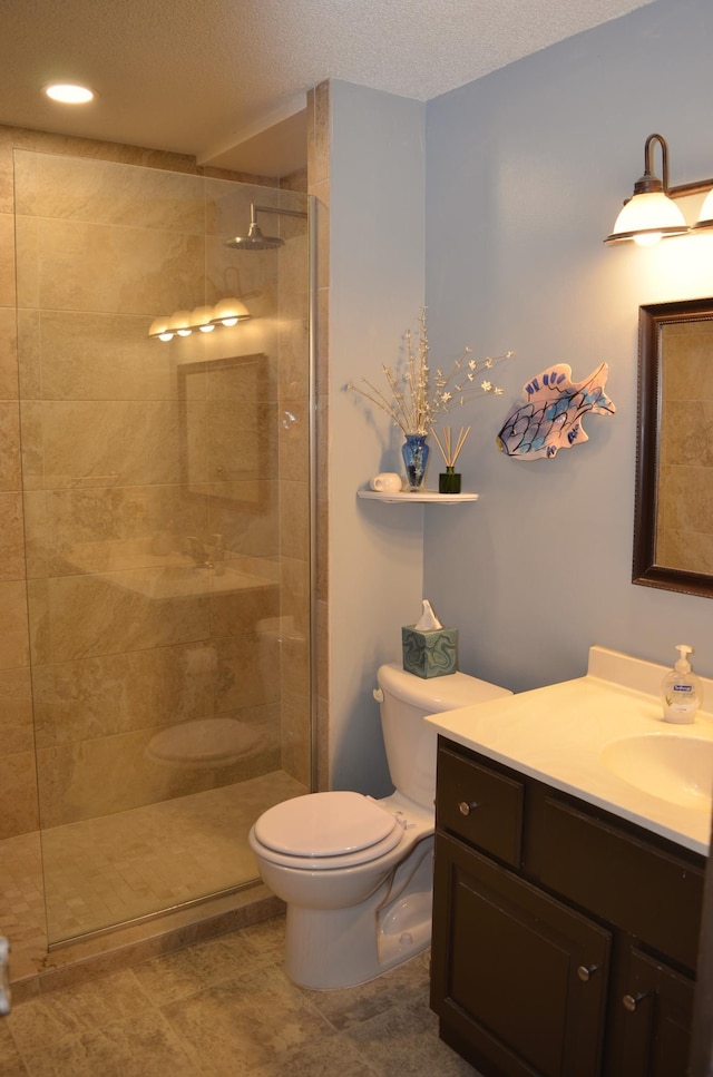 bathroom with a walk in shower, toilet, a textured ceiling, and vanity