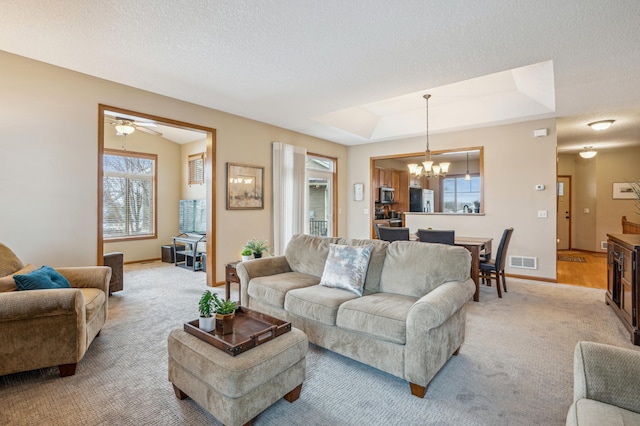 living area featuring light colored carpet, plenty of natural light, and visible vents