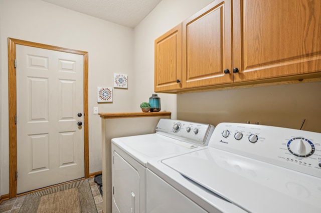 washroom featuring independent washer and dryer, a textured ceiling, baseboards, and cabinet space