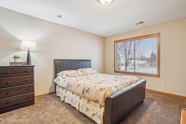 carpeted bedroom with a textured ceiling, baseboards, and visible vents