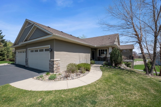ranch-style home featuring an attached garage, a shingled roof, a front lawn, and driveway