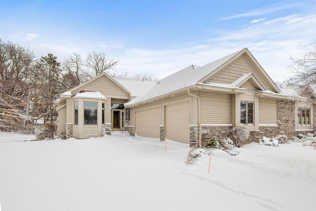 view of front of property featuring a garage and stone siding