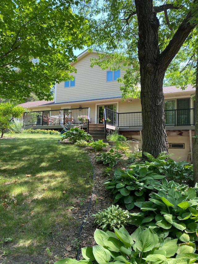 rear view of property with a yard and a wooden deck