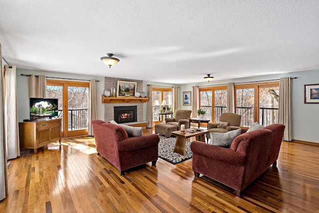 living room featuring a fireplace, a textured ceiling, and hardwood / wood-style floors