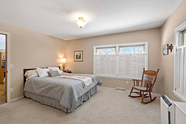 bedroom featuring visible vents, baseboards, carpet, and a textured ceiling