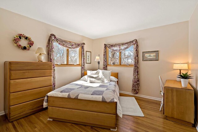 bedroom featuring wood finished floors and baseboards