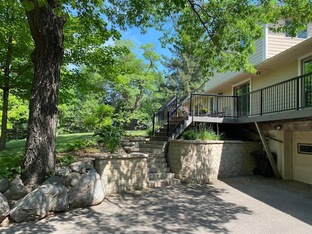 exterior space with aphalt driveway, stairway, a patio area, and a garage